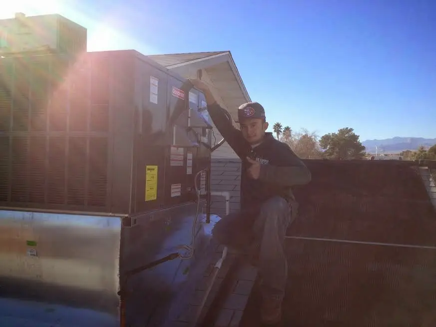HVAC technician performing HVAC Inspection on a rooftop unit in Conover